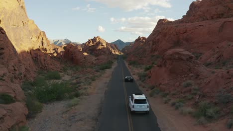 White-Rolls-Royce-and-Black-Ferrari-driving-through-the-canyons-of-the-Valley-of-Fire,-Nevada