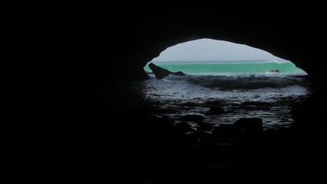Wellen-Rollen-In-Eine-Große-Dunkle-Höhle,-Sonnig-Draußen,-Waenhuiskrans,-Südafrika