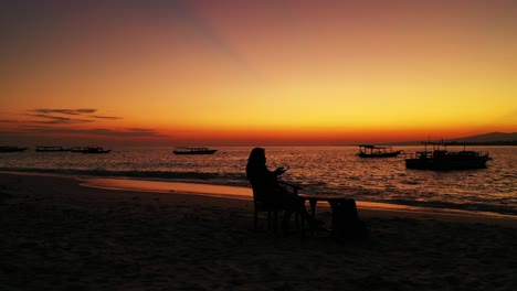 Junge-Frau-Entspannt-Sich-Am-Wasser-Und-Fotografiert-Den-Wunderschönen-Orange-gelben-Sonnenuntergang