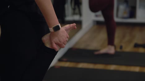 A-close-up-of-a-lady's-hand-and-feet-working-out-in-a-gym,-The-lady-has-a-smart-watch-in-her-hand