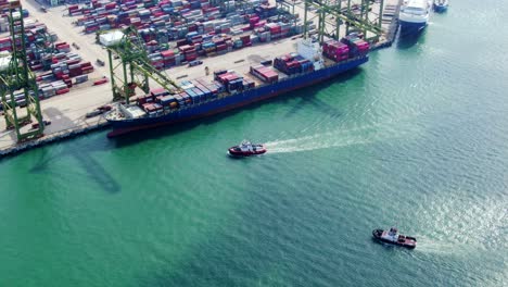Aerial-Footage-of-Boats-Approaching-a-Commercial-Port-Terminal-in-Singapore