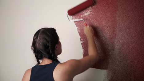 Young-woman-paints-red-wall-in-house
