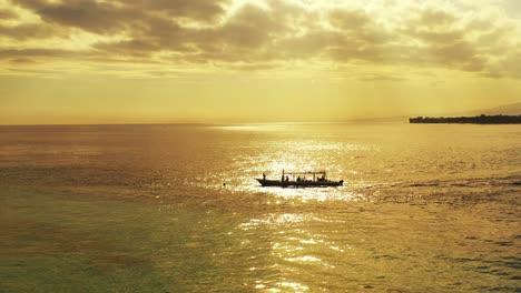 Golden-hour-on-beautiful-seascape-with-bright-sky-over-sea,-boat-sailing-across-calm-clear-water-leaving-shore-toward-tropical-island