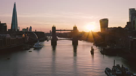Aerial-View-of-London,-including-Towerbridge,-the-Shard,-and-the-river-Thames-as-the-sun-sets