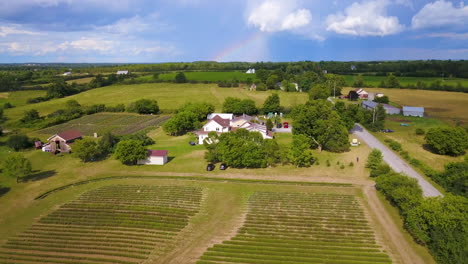 Aerial-rise-over-farmland-with-a-rainbow-in-the-distance