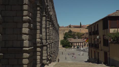 POV-view-walking-down-steps-next-to-ancient-aqueduct-watercourse-in-Segovia,-Spain-near-Madrid