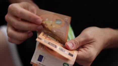 Male-hands-counting-euro-bills-of-100-and-50