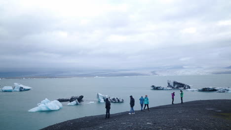 Vatnajokull-Glacier-with-tourists-walking-in-shot-in-front-of-the-ice-lagoon