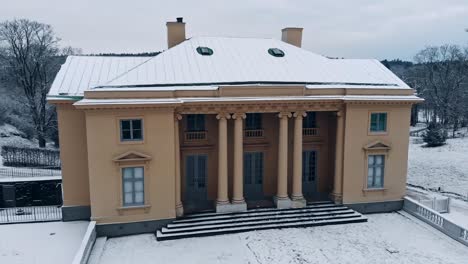 Die-Drohne-Umkreist-Sanft-Den-Schneebedeckten-Gunnebo-Palast-In-Schweden