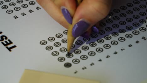 Female-student-checking-test-answer-boxes-with-a-pencil