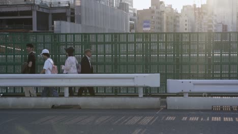 Tokio,-Japan---Menschen-Gehen-Am-Straßenrand-Und-Autos-Bewegen-Sich-Auf-Der-Straße-Von-Tokio---Zeitlupe