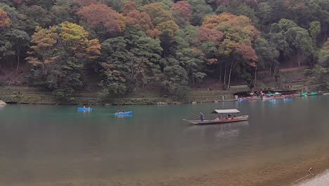 Un-Barquero-Solitario-Comparte-El-Sereno-Río-Katsura-Con-Botes-De-Alquiler,-Kyoto