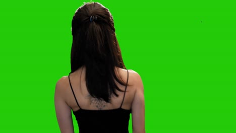 Pretty-petite-girl-adjusts-hair-and-turns-around-and-walks-away-on-green-screen