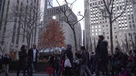 Rockefeller-Center-Christmas-Tree,-Low-Angle-Closeup-View-with-People-Walking-By,-Families-Spending-Time-Together-During-Holiday-Season