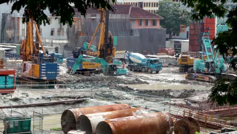 A-small-excavator-moves-cement-slop-in-a-construction-site-in-Singapore's-business-district