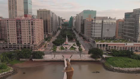 Rising-aerial-shot-behind-Kun-Iam-golden-statue-in-NAPE-business-area-in-Macau