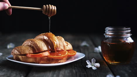 Dripping-honey-on-croissant-stuffed-with-orange
