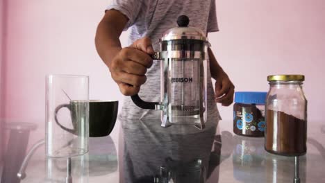 Man-making-coffee-with-French-press-coffee-maker-at-home