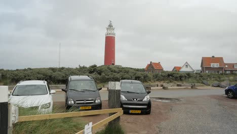 Wide-shot-showing-dutch-parking-cars-and-famous-Lighthouse-On-Dutch-Island-Texel