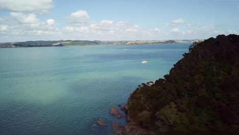 Aerial-drone-soars-over-cliff-to-reveal-Waihihi-Bay-in-the-Bay-of-Islands-on-a-summers-day