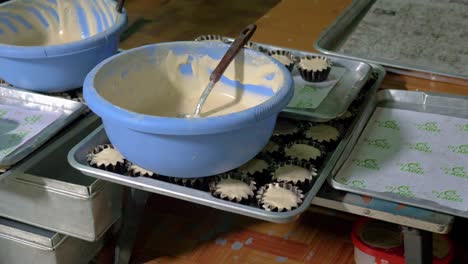 Bowls-of-cupcake-batter-over-trays-with-cupcakes-in-baking-cups-ready-for-baking