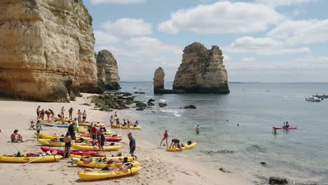 Kayakers-beach-boats-on-private-Algarve-beach-near-Lagos,-Portugal