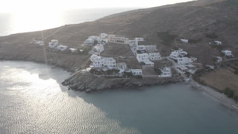 Descending-aerial-drone-flight-overlooking-few-white-houses-at-the-island-of-tinos