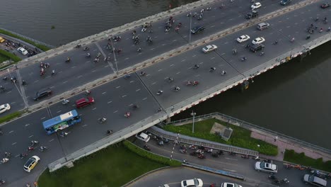 High-aerial-panning-view-of-evening-traffic-over-Dien-Bien-Phu-Bridge,-Binh-Thanh-district,-Ho-Chi-Minh-City,-Vietnam-which-crosses-the-Hoang-Sa-canal