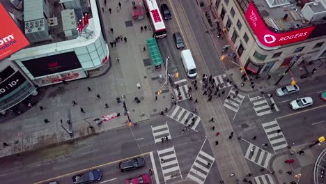 Busy-People-Cross-the-Street-in-All-Directions,-Wide-Aerial-Overhead
