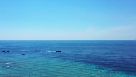 Bahamas-Beach-Showing-A-Ship-Sailing-Horizontally-Across-The-Blue-Ocean---Wide-Shot