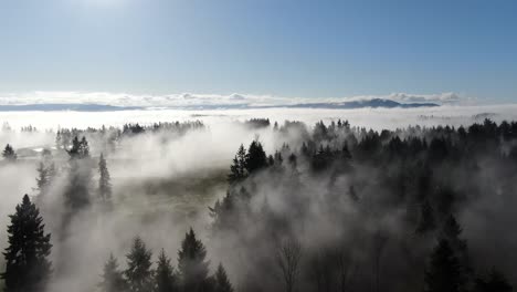 4K-Drone-flight-above-fog-and-clouds-over-a-wilderness-landscape-on-a-bright-sunny-day