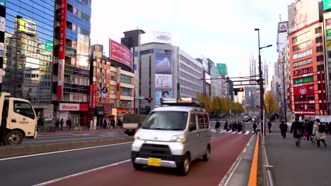 Straßen-Von-Shinjuku-Bei-Tag,-Gimbal-Bewegte-Aufnahme-Einer-Belebten-Straße-In-Tokio-Mit-Sich-Bewegenden-Autos-Und-Menschen,-4K-Videos-Aus-Japan