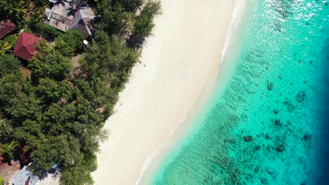 Idyllischer-Exotischer-Strand-Mit-Weißem-Sand-Vor-Klarem,-Ruhigem-Wasser-Einer-Flachen-Türkisfarbenen-Lagune-Mit-Korallen-Und-Felsen-Am-Meeresboden-Der-Küste-Von-Bali