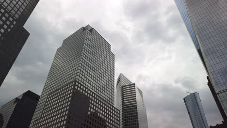 Rascacielos-Modernos-Con-Fachadas-De-Vidrio,-Manhattan,-Distrito-Financiero-Y-De-Negocios-De-Nueva-York,-Cielo-Reflejado-En-Las-Ventanas