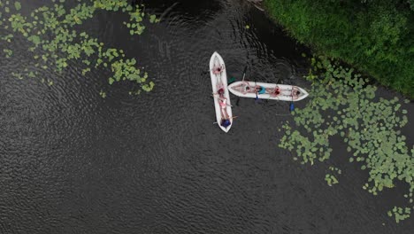 Luftaufnahme-Aus-Der-Vogelperspektive-Von-Zwei-Mit-Menschen-Gefüllten-Kanus-In-Einem-Fluss-In-Der-Wildnis