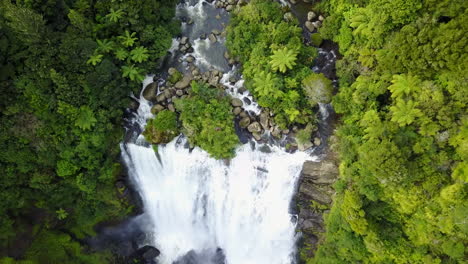 Aerial-Top-view-of-the-river-in-green-forest-moving-to-waterfall-in-New-Zealand