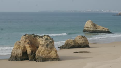 Man-and-Dog-Walking-Alone-Close-to-Rock-Formations-Rock-Beach-Portimão