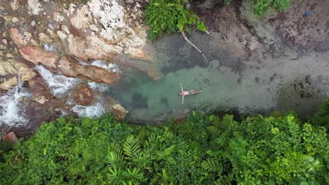 Ein-Junger-Mann-Mit-Roter,-Sonnenverbrannter-Haut-Von-Der-Sonne-Kühlt-Sich-Ab-Und-Schwimmt-Auf-Der-Oberfläche-Des-Frischen-Und-Durchsichtigen-Wassers-Eines-Flusses-In-Neubritannien,-Papua-Neuguinea