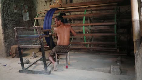 Trabajador-Rural-Hilando-Hilos-De-Algodón-Azul-En-Una-Máquina-En-Una-Fábrica-Textil,-Industria-De-Fabricación-De-Telas