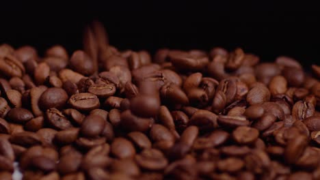 Falling-brown-roasted-coffee-beans-in-professional-studio-lights-and-black-background