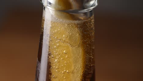 Bubbles-of-carbon-dioxide-rise-in-the-head-of-a-fresh-beer-bottle---Close-up