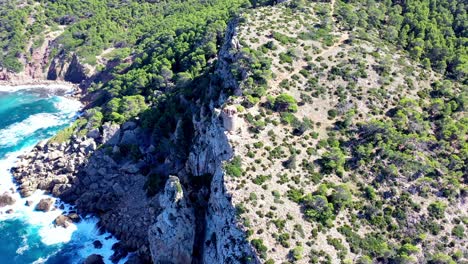 Fortified-Tower-of-Basset-Cove-in-Mallorca-Spain-overlooking-the-Mediterranean-sea,-Aerial-flyover-shot