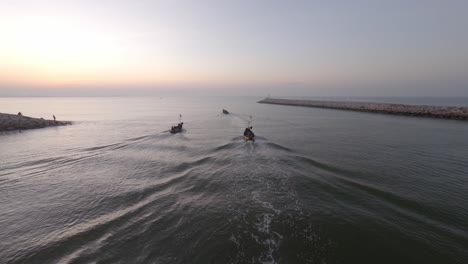 Luftaufnahme:-Nach-Oben-Geneigte-Aufnahme-Von-Fischerbooten,-Die-Bei-Sonnenaufgang-In-Den-Offenen-Ozean-Schwimmen,-Um-Fische-Zu-Fangen