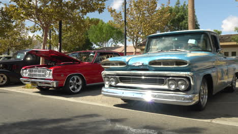 Classic-Chevy-C10-truck-and-Impala-coupe-on-display,-tracking