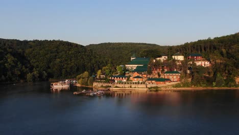 Niedrige-Luftaufnahme-Eines-Resorts-Am-Flussufer-In-Den-Hügeln-Der-Ukraine-Bei-Sonnenaufgang