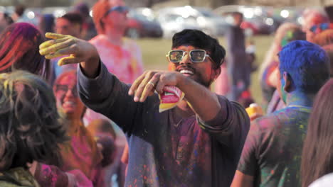 Man-is-showered-with-colored-powder-while-dancing-at-Holi-Festival