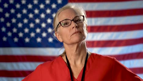 Portrait-of-a-nurse-showing-a-seriousness-and-disapproval-set-against-an-out-of-focus-US-flag
