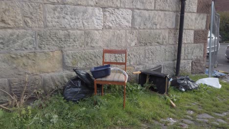 Zerbrochene-Stühle-Und-Schwarze-Müllsäcke,-Die-In-Einer-Seitenstraße-Zurückgelassen-Wurden