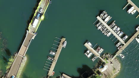 Aerial-top-down,-drone-shot-above-a-cable-ferry-and-a-harbor,-in-the-archipelago-of-Porvoo,-sunny,-spring-day,-in-Uusimaa,-Finland