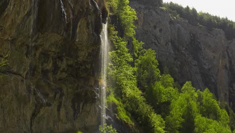 Water-cascading-down-rock-face-caught-in-sunlight,-Spanish-Pyrenees